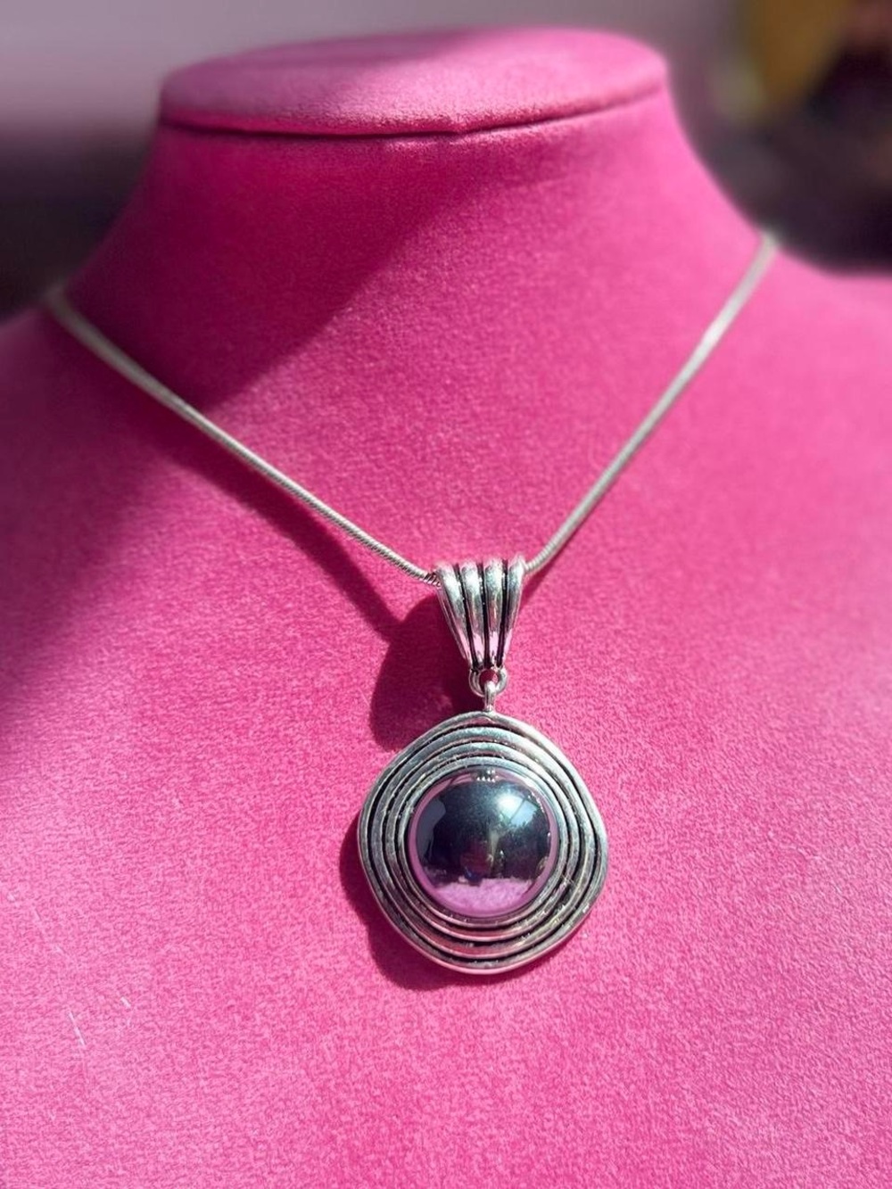 Silver tone swirl pendant with a dark grey marble stone